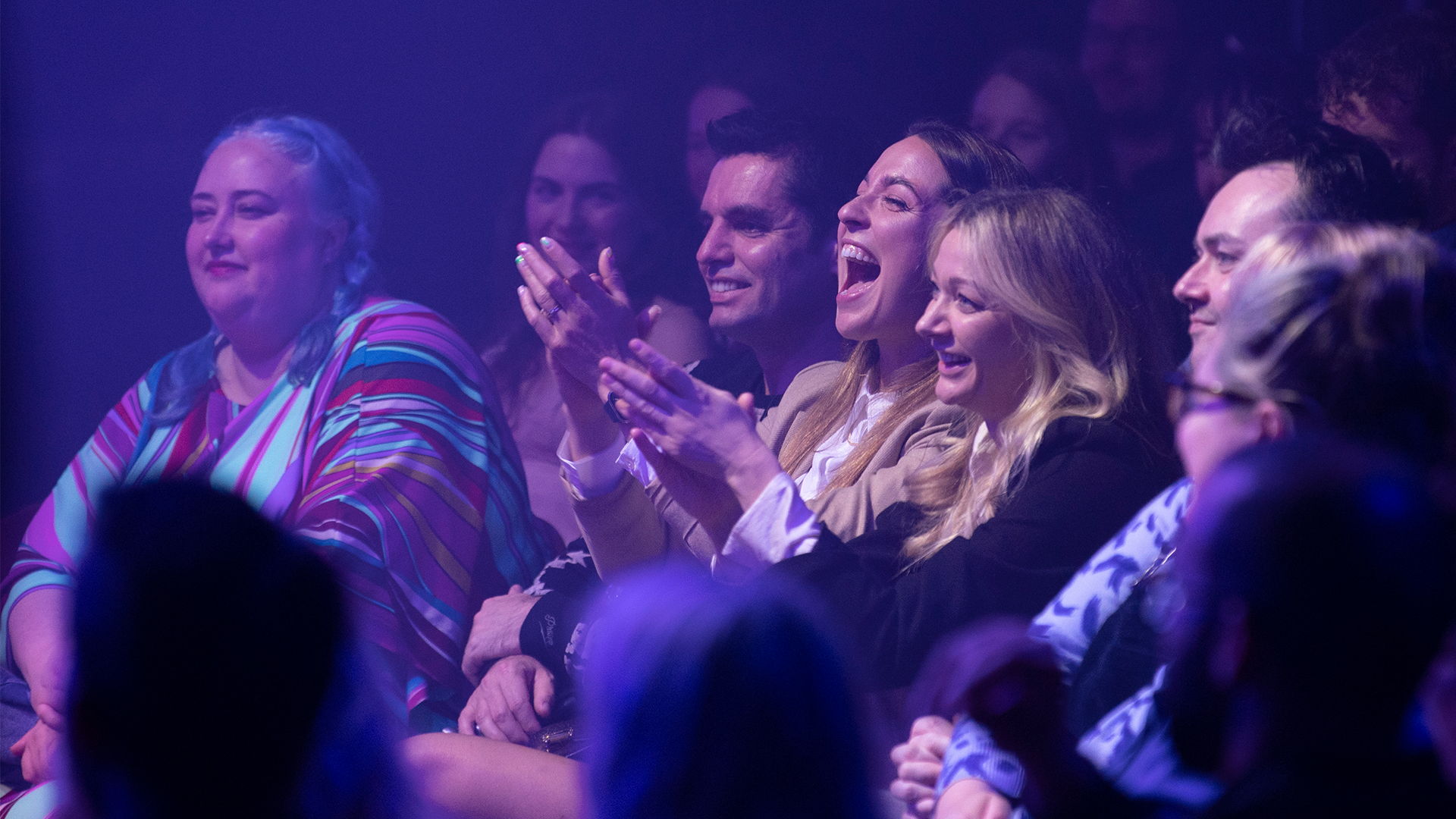 audience members laughing and clapping